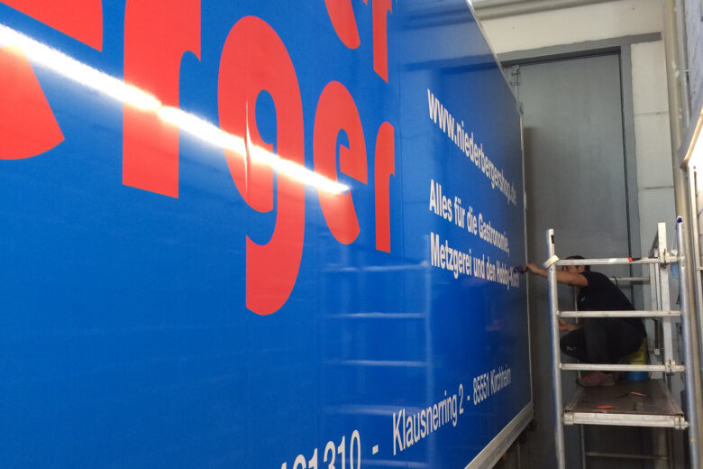 Blauer Lieferwagen mit dem Schriftzug 'Mieder Berger' in roter Schrift an der Seite.