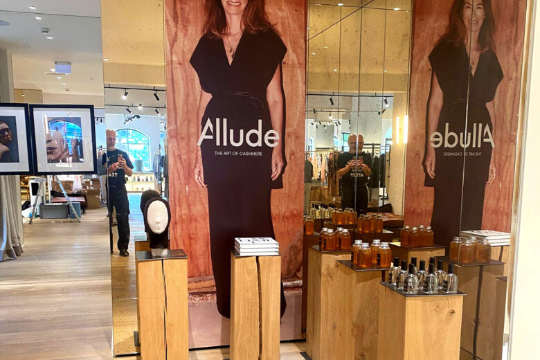 Präsentation der Marke Allude mit einer großen Wandgrafik und Produkten in einem Geschäft.
