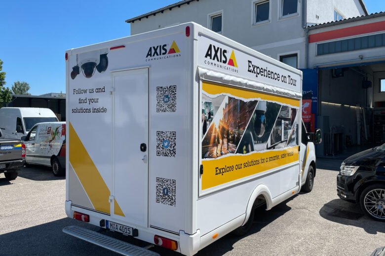 Ein Fahrzeug von AXIS Communications mit Werbung und QR-Codes auf der Rückseite.