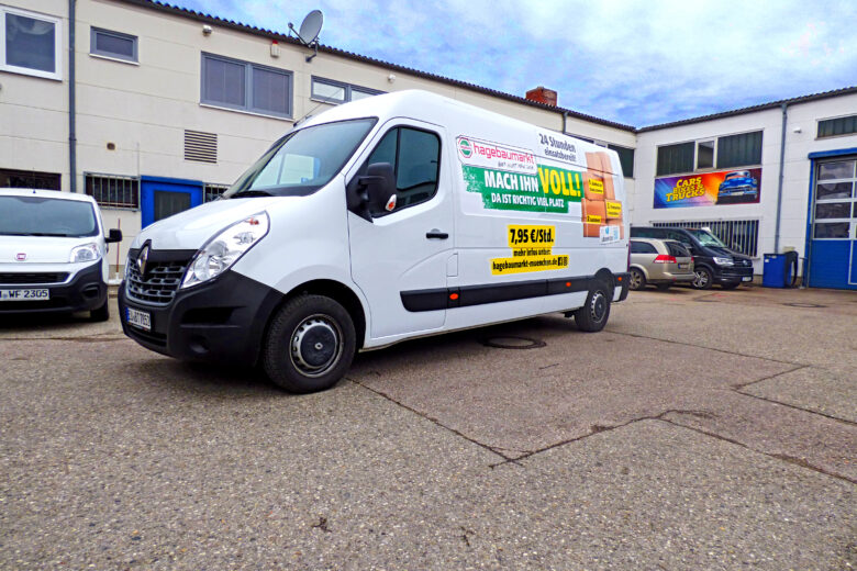 Weißer Transporter mit Werbung für eine Umzugsfirma auf der Seite.