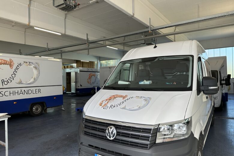 Weißer Volkswagen Transporter mit dem La Poissonnerie Logo in einer Halle.