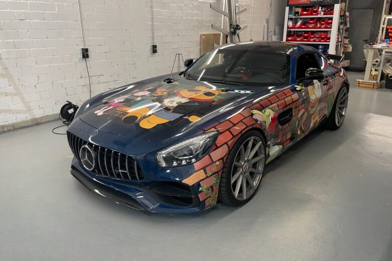 Mercedes-AMG mit einer bunten Comic-Folierung, die verschiedene Charaktere darstellt.