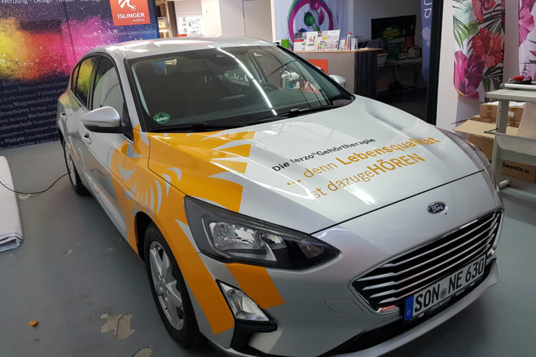 Ein Ford Fahrzeug mit einer bunten Folierung, die den Schriftzug von ISLINGER GmbH zeigt.