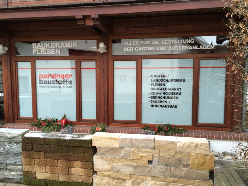 Schaufenster des Parzinger Baustoffe Geschäfts mit verschiedenen Dienstleistungen und Angeboten.
