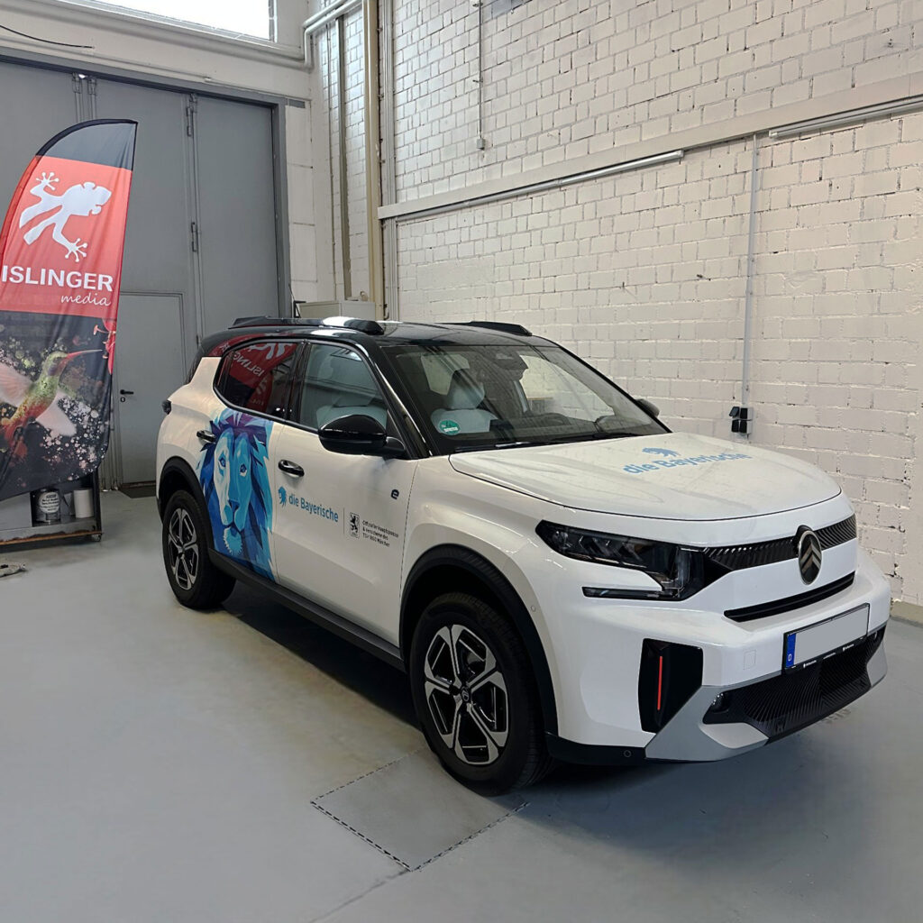 Weißes Fahrzeug der ISLINGER GmbH mit blauer Werbegrafik und Logo auf der Seite.