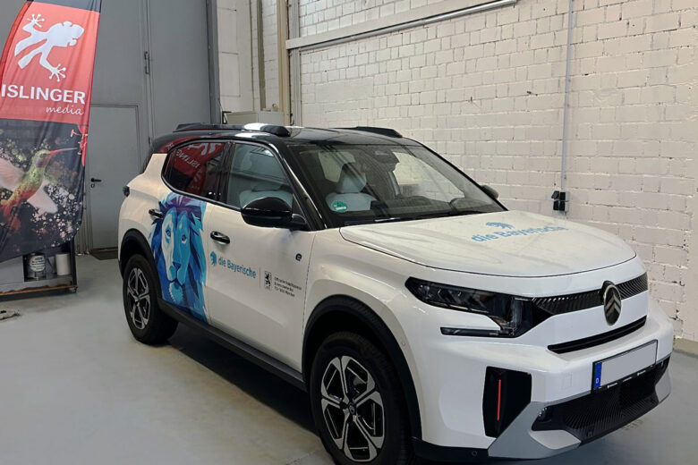 Weißes Fahrzeug der ISLINGER GmbH mit blauer Werbegrafik und Logo auf der Seite.