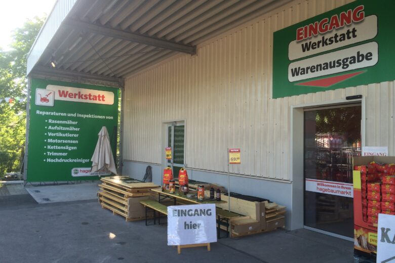 Eingang zur Werkstatt mit Schildern und Produkten im Außenbereich.