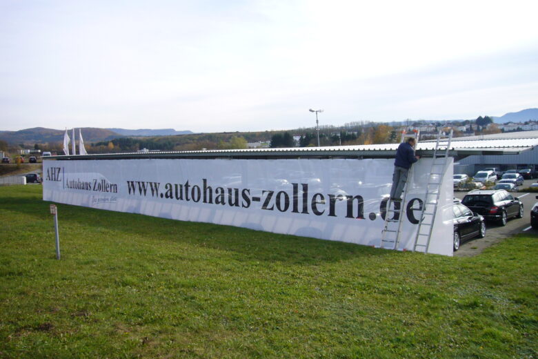 Großes Werbebanner mit der Aufschrift 'autohaus-zollern.de' auf einem Gelände.