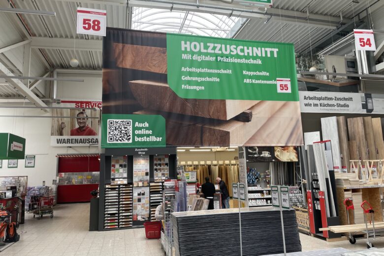 Banner für Holzzuschnitt mit digitaler Präzisionstechnik in einem Baumarkt.