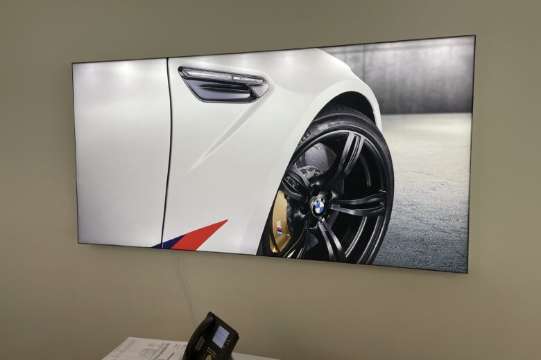 Nahaufnahme eines BMW M Fahrzeugs mit schwarzem Rad und gelben Bremssätteln auf einem Bildschirm.