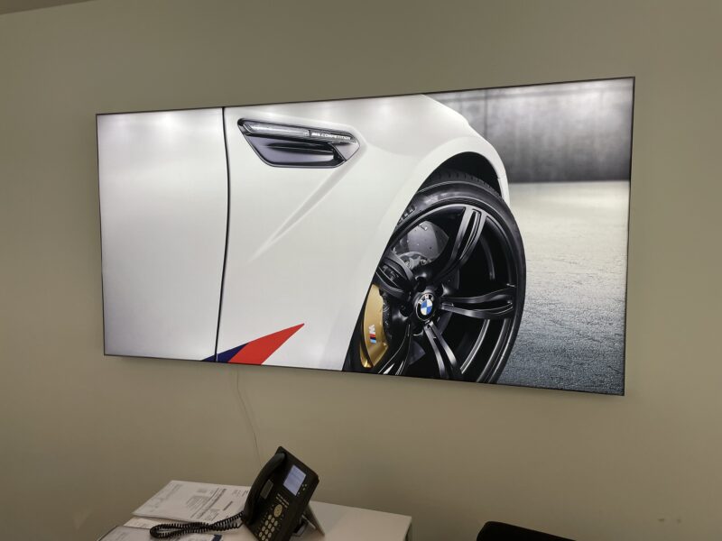 Nahaufnahme eines BMW M Fahrzeugs mit schwarzem Rad und gelben Bremssätteln auf einem Bildschirm.